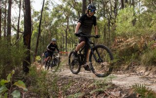 Group of three mountain bikers riding up Hey Hey My My trail in the forest at Wesburn