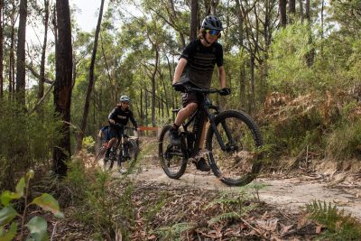 Group of three mountain bikers riding up Hey Hey My My trail in the forest at Wesburn
